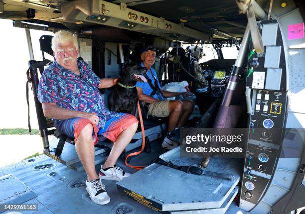 Tom O'Sullivan along with his dog Jack and Harry Marquard prepare to be evacuated in a Florida Army National Guard helicopter on October 02, 2022 in...