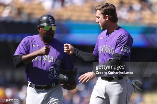 Stu Cole and Ryan McMahon of the Colorado Rockies fist-bump between innings during a game against the Los Angeles Dodgers at Dodger Stadium on...