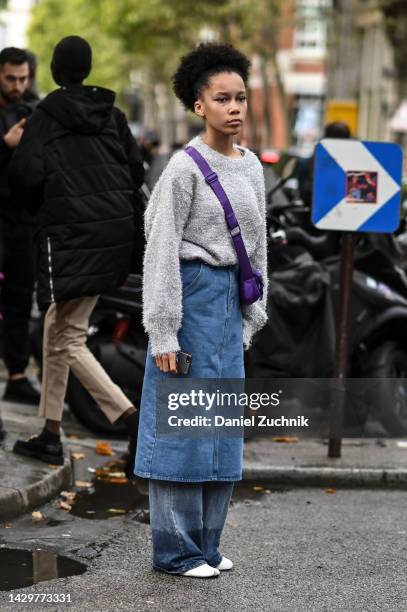 Guest is seen wearing a gray sweatshirt, jean skirt and jean pants with purple cross body bag outside the Valentino show during Paris Fashion Week...