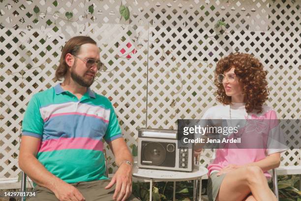 retro 1980s couple candid portrait of funny 1980s style fashion and 80s hairstyles - backyard retro stock-fotos und bilder