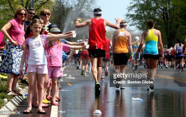 Jessica Coomber and her fellow John Ward Schoolmates offer water to Boston Marathon runners as they start their spring vacation on Commonwealth...