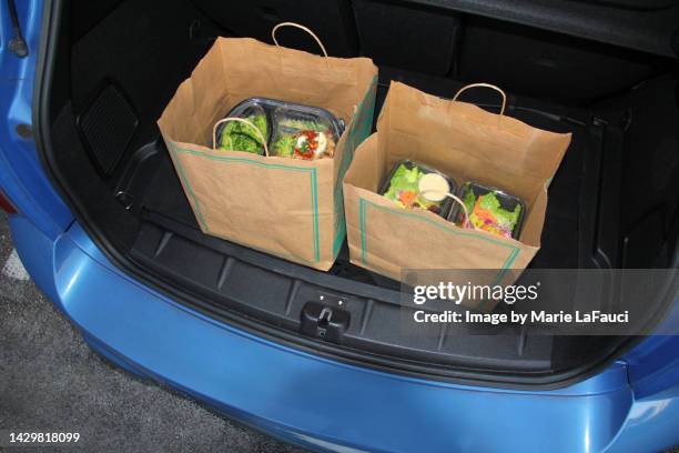 take-out food in trunk of car using curbside pick-up - papier tasche offen stock-fotos und bilder