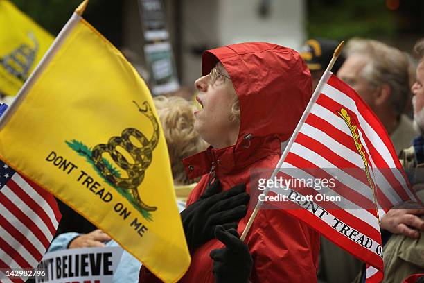 Kay Herrmann sings the National Anthem at the start of a Tea Party rally which was held to protest President Barack Obama's proposed "Buffett rule"...