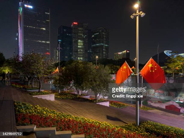 chinese flag fluttering in the wind in hangzhou's business district during china's national day - china flag stock pictures, royalty-free photos & images