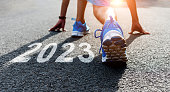 Young sports man preparing to run with new year number 2023 on the road