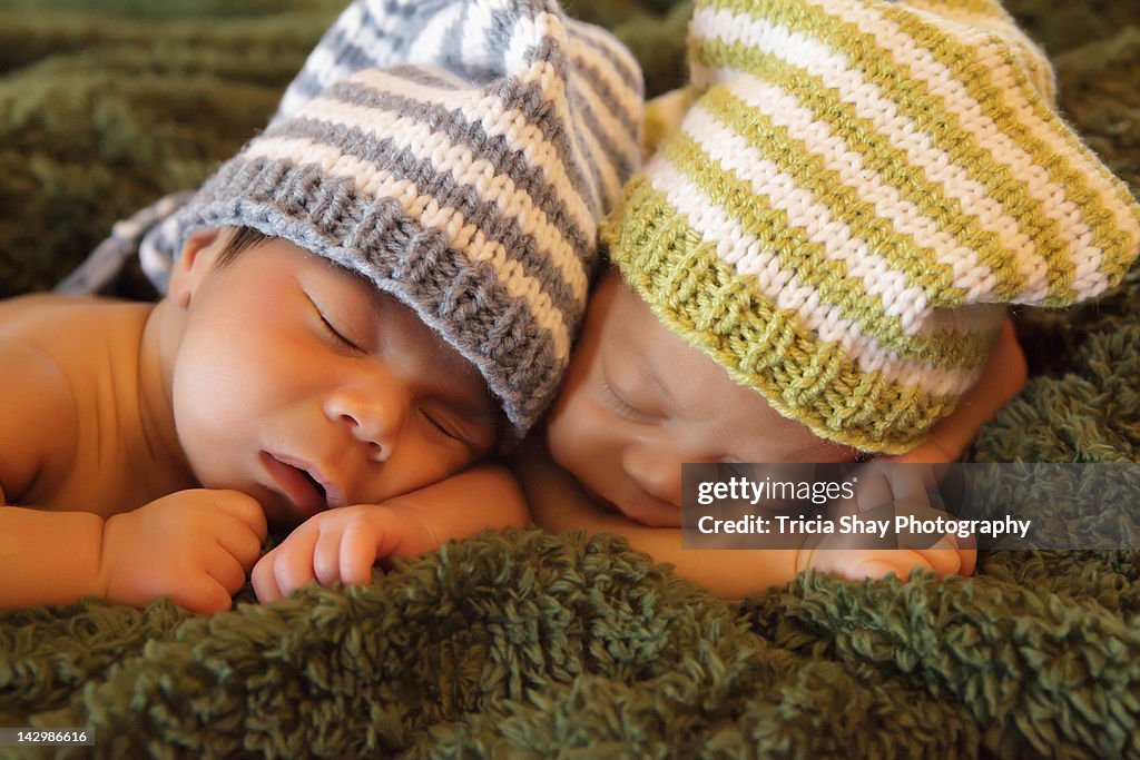 Twin newborns with knit caps on