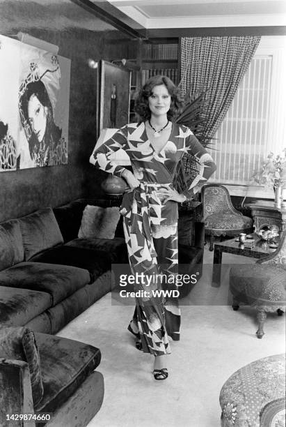 Model wears a Diane von Furstenberg seagull-printed wrap dress and poses in the designer's apartment. An Andy Warhol portrait of Diane von...