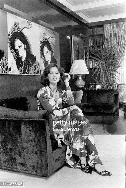 Model wears a Diane von Furstenberg seagull-printed wrap dress and poses in the designer's apartment. An Andy Warhol portrait of Diane von...