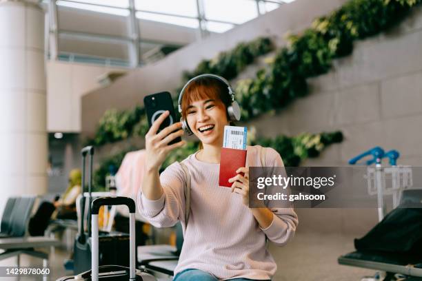 空港での幸せな女性のビデオ通話 - 飛行機の搭乗券 ストックフォトと画像