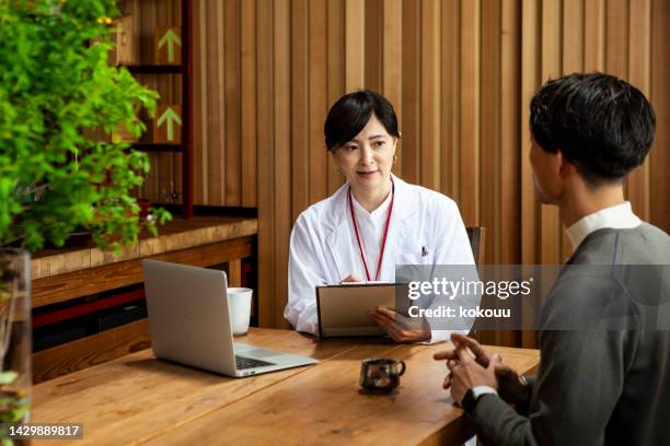 woman psychologist talking to young man patient. - branch office stock pictures, royalty-free photos & images