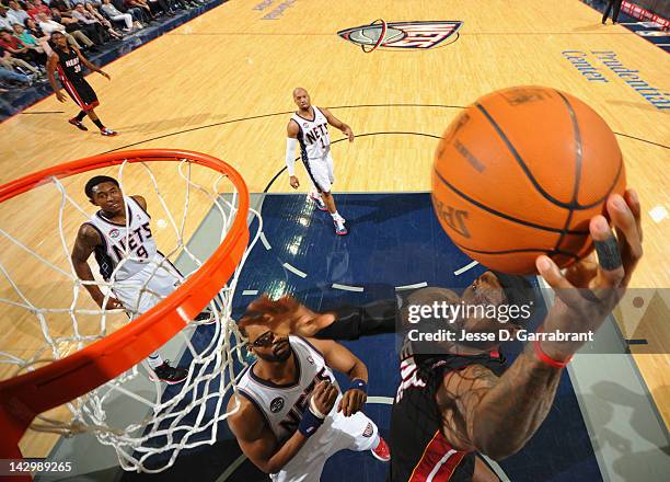 LeBron James of the Miami Heat goes to the basket against Shelden Williams of the New Jersey Nets during the game on April 16, 2012 at the Prudential...