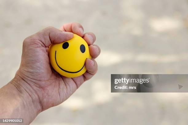 hand squeezing a stress ball - squeezing stock pictures, royalty-free photos & images