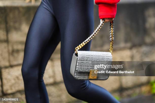 Yuwei Zhangzou wears a red buttoned bomber coat, black nylon pointed / heels legging shoes pants, a grey embossed velvet handbag from Givenchy,...