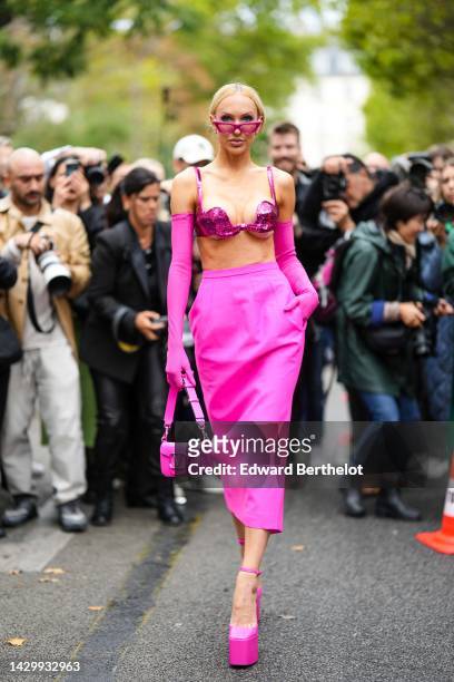 Christine Bently aka Christine Quinn wears neon pink cat eyes sunglasses, a neon pink sequined bra underwear, neon pink high gloves, a neon pink...