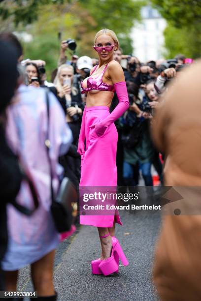 Christine Bently aka Christine Quinn wears neon pink cat eyes sunglasses, a neon pink sequined bra underwear, neon pink high gloves, a neon pink...