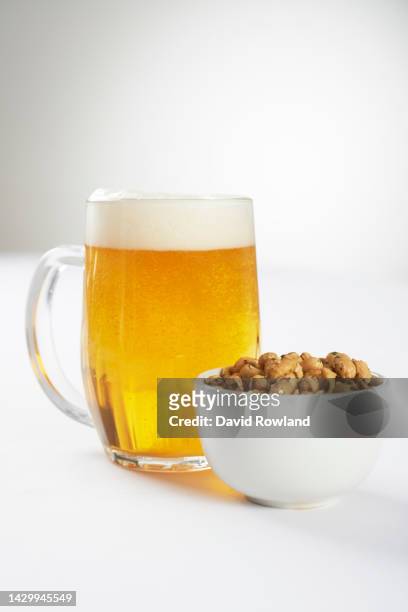 a pint of beer and a bowl of nuts - artisanal food and drink uk imagens e fotografias de stock