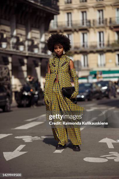 Sarah Monteil wearing black and yellow checkered pats, matching sleevless coat, matching long gloves, and black bag outside Giambattista Valli during...