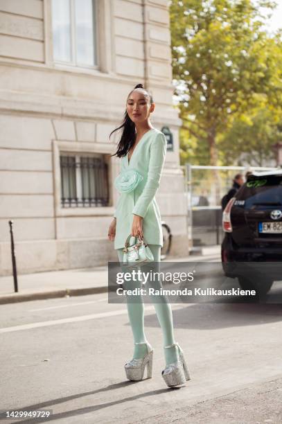 Korlan Madi wearing pale green or mint green long sleeves mini dress, matching color tights, matching color Hermes mini bag, and silver glitter...