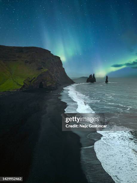 luzes do norte sobre a praia de areia preta reynisfjara na islândia - islandia - fotografias e filmes do acervo
