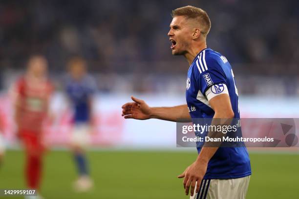 Simon Terodde of Schalke argues with the assistant referee during the Bundesliga match between FC Schalke 04 and FC Augsburg at Veltins-Arena on...