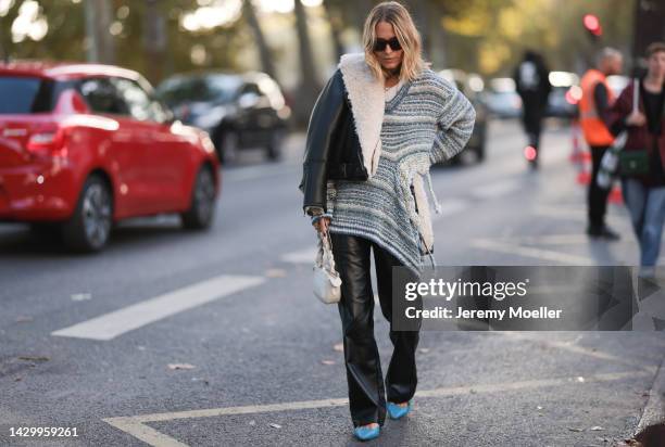 Fashion week guest seen wearing a knit sweater and leather pants, outside Akris during Paris Fashion Week on October 01, 2022 in Paris, France.