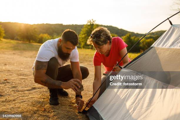 accampamento sul prato durante un tramonto dell'ora d'oro - picchetto da tenda foto e immagini stock