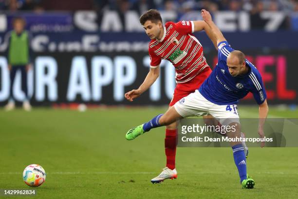 Henning Matriciani of Schalke battles for the ball with Elvis Rexhbecaj of FC Augsburg during the Bundesliga match between FC Schalke 04 and FC...