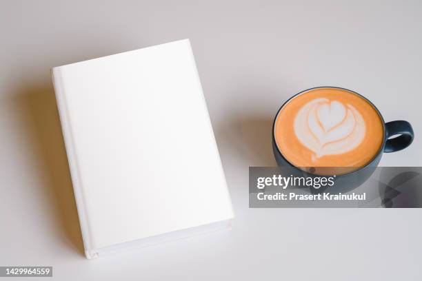 hot cup of coffee with blank white book on white table - mug mockup stock pictures, royalty-free photos & images