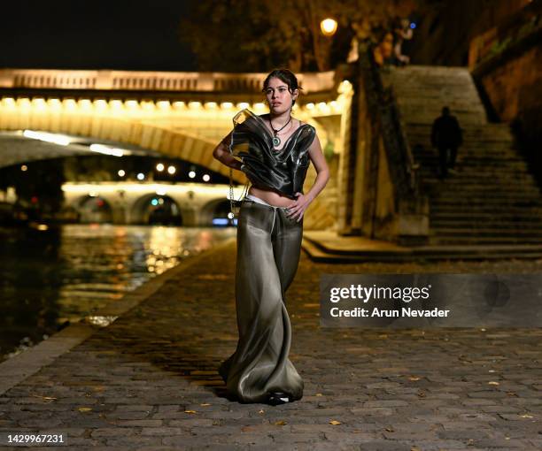 Model poses in the Ile Saint-Louis in an Ashlyn So design with jewelry by Love You More and shoes by Nike on October 02, 2022 in Paris, France.