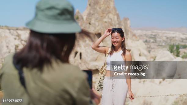 woman taking photos of her friend in nature of cappadocia türkiye - only japanese stock pictures, royalty-free photos & images