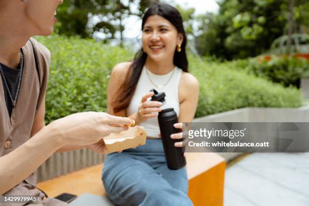 two friendships eating snacks while taking a break. - colleague lunch stock pictures, royalty-free photos & images