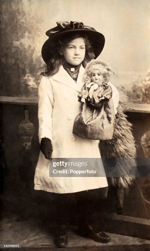 Studio Portrait Of A Young Girl And Her Doll