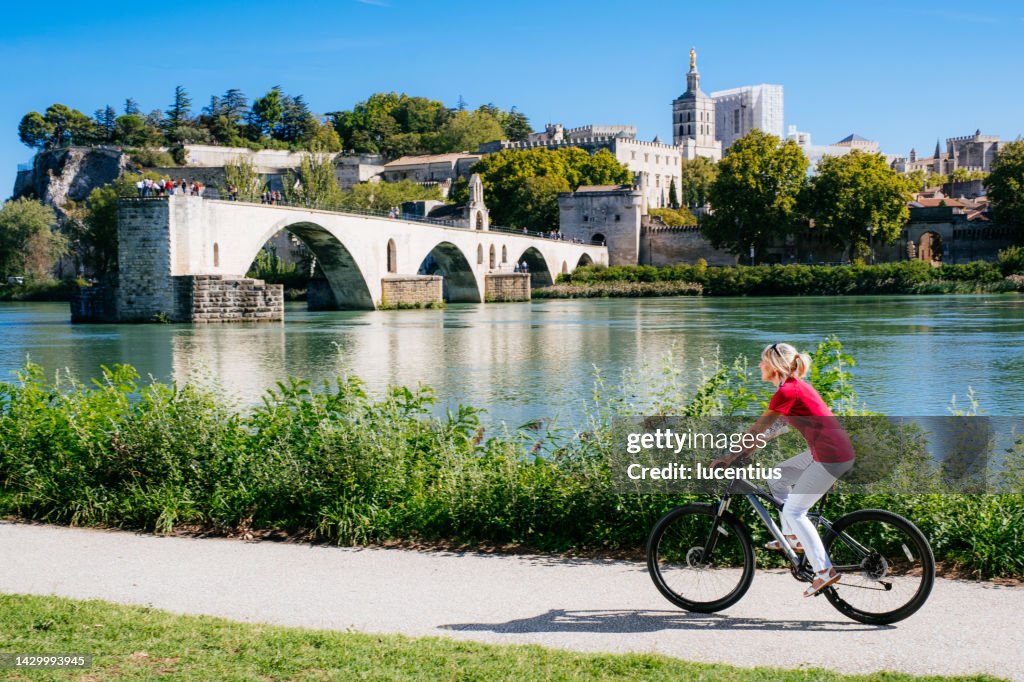 Summer cycling beside Pont Saint Benezet, Avignon, France