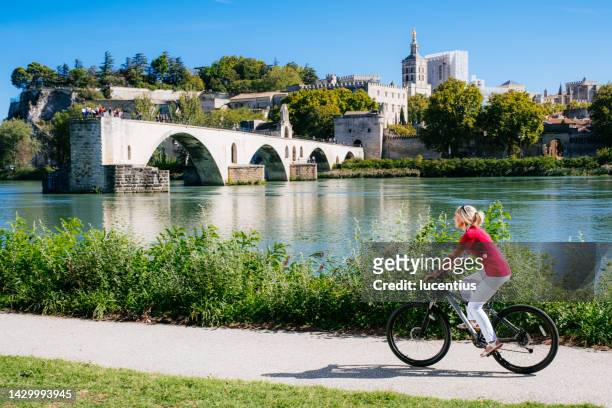 summer cycling beside pont saint benezet, avignon, france - rhone valley stock pictures, royalty-free photos & images