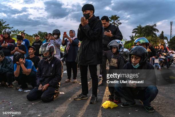 People and supporters of Arema FC mourn as they pay condolence to the victims outside Kanjuruhan Stadium on October 03, 2022 in Malang, Indonesia. A...