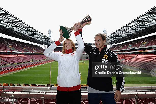 Goalkeeper Kathrin Laengert of Muenchen and Desiree Schumann of Frankfurt pose with the Women's DFB Cup trophy during the Women's DFB Cup Final press...