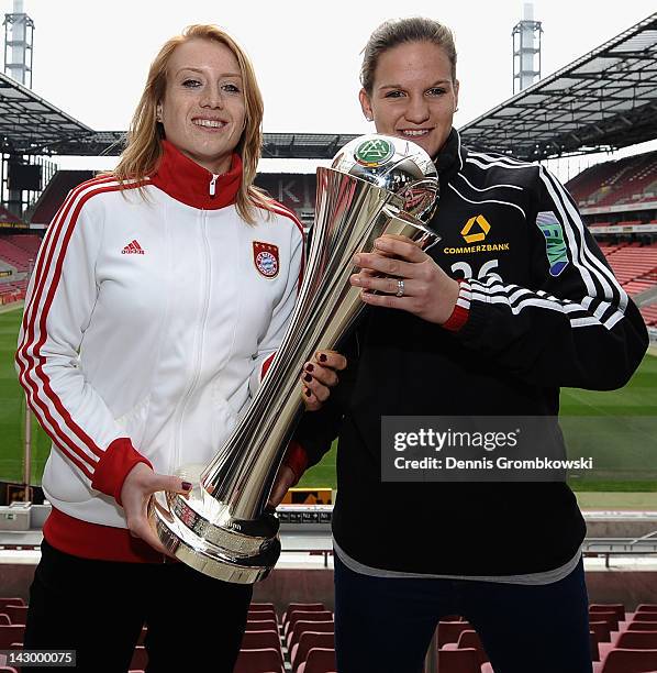 Goalkeeper Kathrin Laengert of Muenchen and Desiree Schumann of Frankfurt pose with the Women's DFB Cup trophy during the Women's DFB Cup Final press...