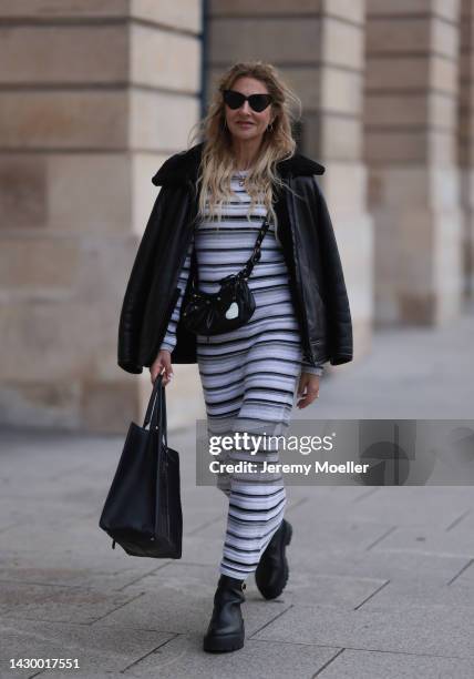 Sue Giers wearing SoSue striped knit dress, black Celine boots, Balenciaga bag, Balenciaga le Cagole black bag, black Balenciaga shades, black...