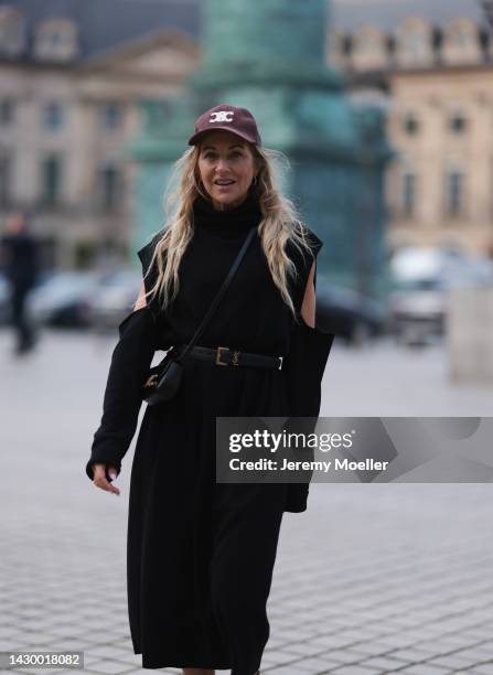 Sue Giers wearing black SoSue knit long dress, YSL black gold leather belt, black Celine mini bag and red Celine cap during Paris Fashion on October...