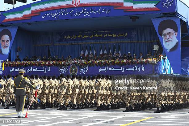President Mahmoud Ahmadinejad stands alongside military commanders of the Iranian armed forces as they watch soldiers march during a parade...