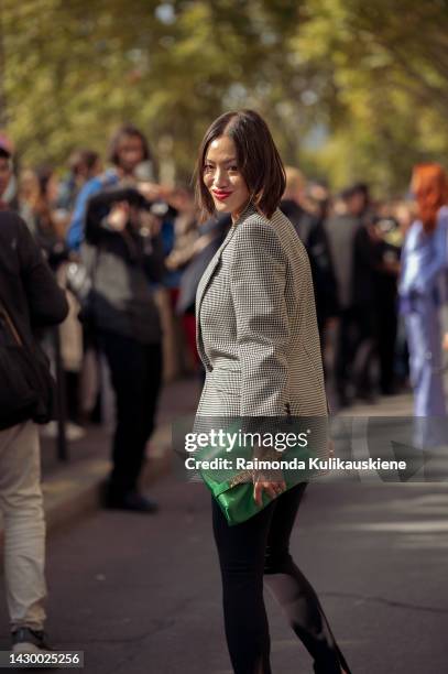 Tiffany Hsu wearing black leggings, a grey jacket, and a green bag outside Giambattista Valli during Paris Fashion Week - Womenswear Spring/Summer...