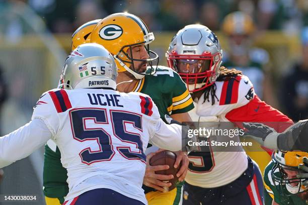Aaron Rodgers of the Green Bay Packers is sacked by Matthew Judon and Josh Uche of the New England Patriots during a game at Lambeau Field on October...