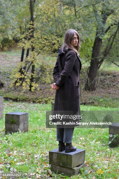 portrait of a young woman in a black coat. - female looking away from camera serious thinking outside natural stock-fotos und bilder