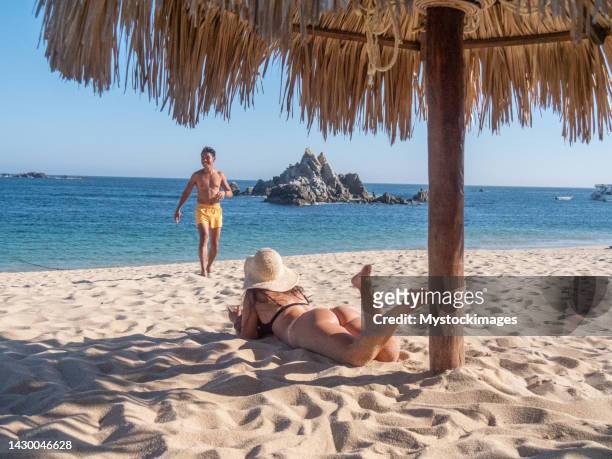 multiracial couple sunbathing on the beach in mexico - hot filipina women stockfoto's en -beelden