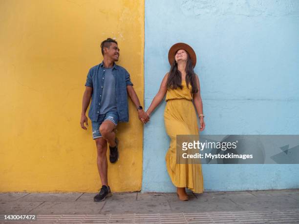colour game, couple against colourful wall - central american games stock pictures, royalty-free photos & images