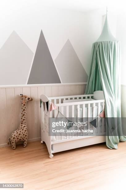 baby room with white crib and decoration in neutral tones, sunlight coming through the window. - kinderkamer stockfoto's en -beelden