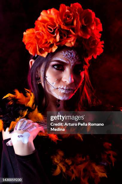 portrait of a woman made up as a catrina with orange flowers on her head. - pan de muerto stockfoto's en -beelden