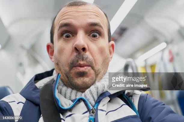 middle-aged caucasian man with black hair, beard and brown eyes with a surprised expression. - surprised face stock-fotos und bilder