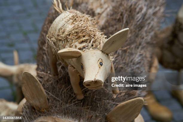 handicraft of wooden pig on another wooden pig, with details in the eye and trunk. - 彫刻物 ストックフォトと画像