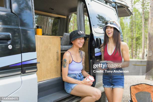 two young woman talking and laughing at van campsite - funny lesbian 個照片及圖片檔